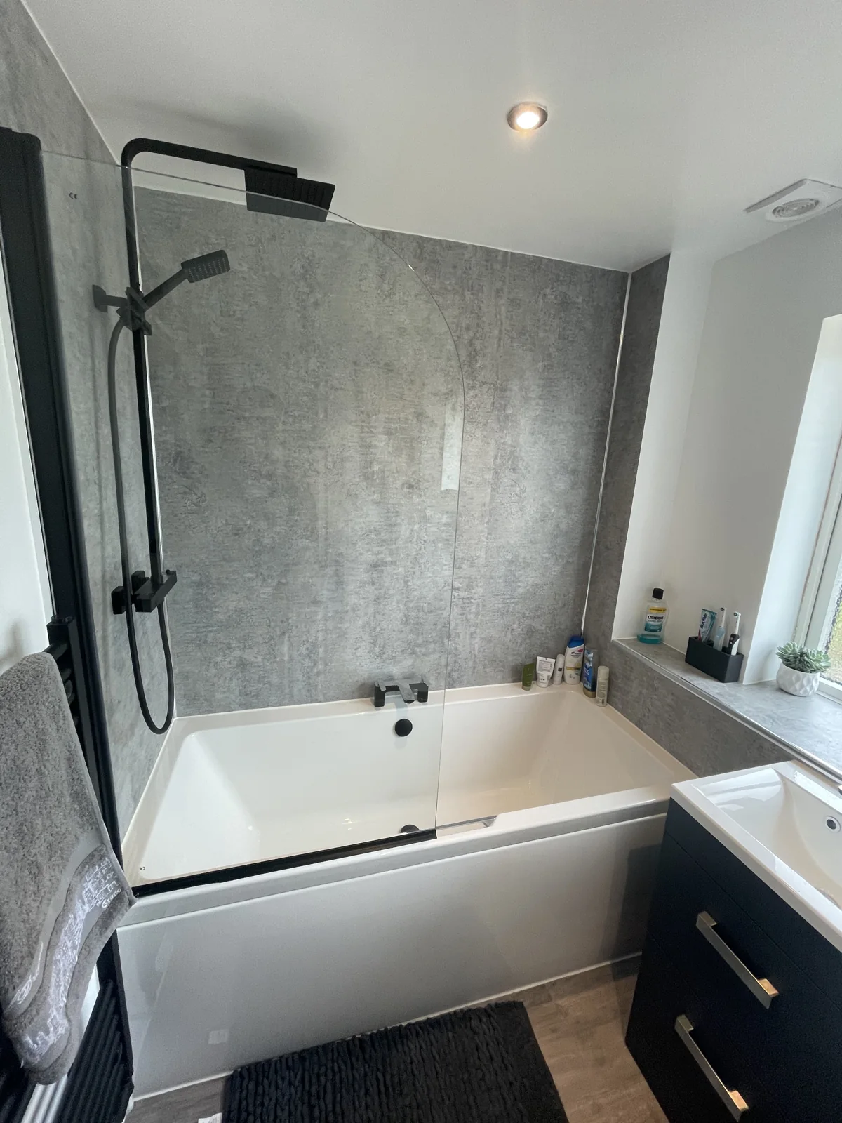 Bath with glass screen and black shower fittings
